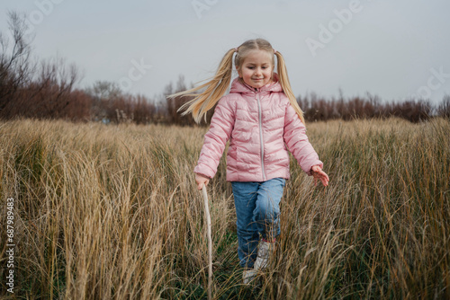 A cheerful young girl twirls with hair flying in a field, captured in a moment of pure happiness and freedom photo