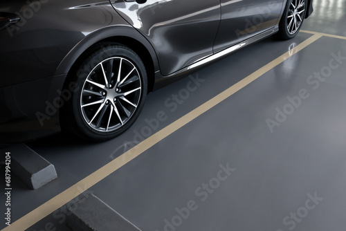 modern car in parking lot, anti slip coating floor for safety, car parked in the right position in modern building carpark area, image with copy space for banner background, diagonal composition photo