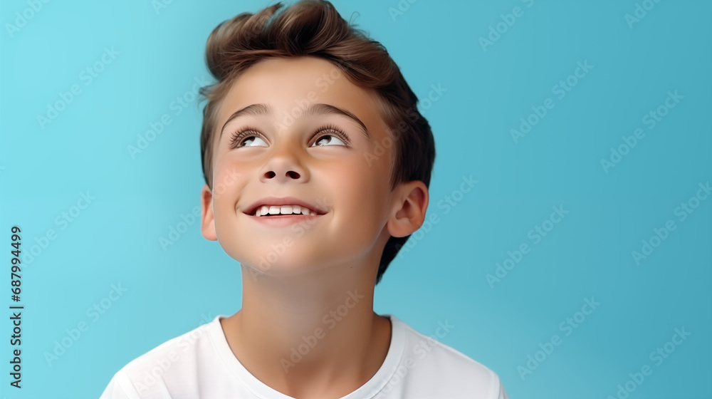 young boy smiling and looking happy on a blue background young boy smiling and looking happy on a blue background