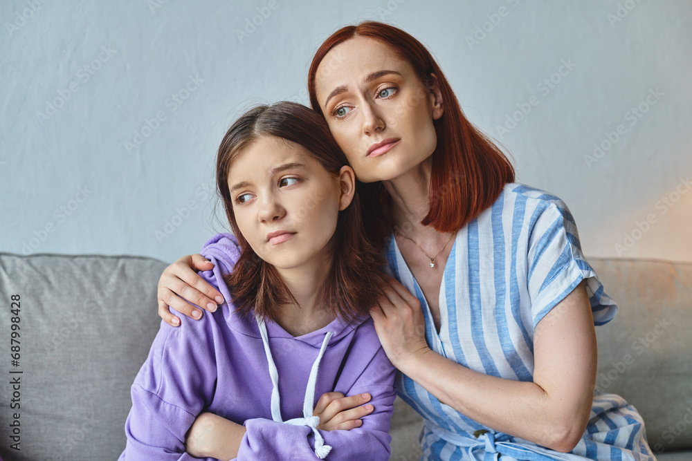 worried mother embracing and calming upset teenage daughter at home in living room, support and care worried mother embracing and calming upset teenage daughter at home in living room, support and care