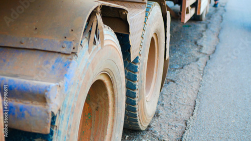 Close-up view of the dirty tires of a large truck covered with soil and dry mud.