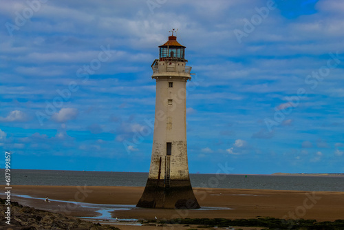 An historic Lighthouse on the beach with the sea in the background.