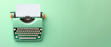 Light green typewriter on a light green background. Concept of creativity. Place for text, banner