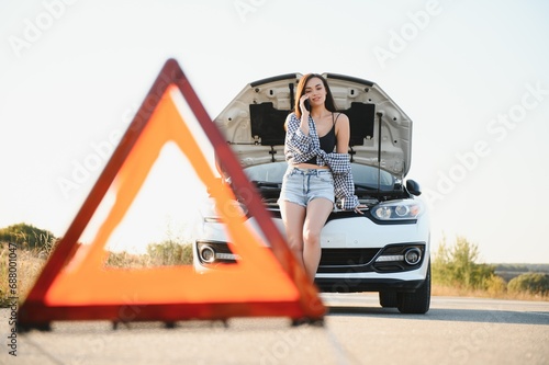 Young sexy woman with broken car calling on the cell phone. photo