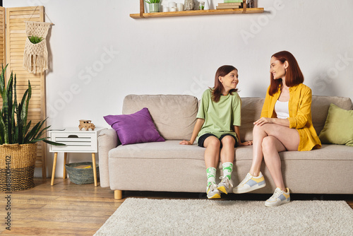 Quadro em tela joyful mother and teenage daughter talking about sex education on couch in livin