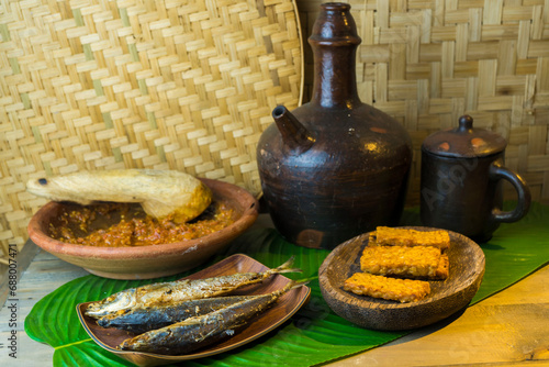 Traditional foods of Indonesia contains fried fish, tofu, tempeh and the shrimp paste chilli with the Kendi or earthenware jug contain drink. photo