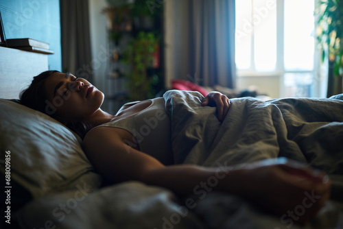Young woman sleeping on bed in bedroom at home photo