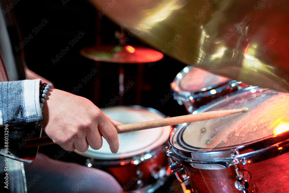 Naklejka premium Male hands playing a drum kit on stage.
