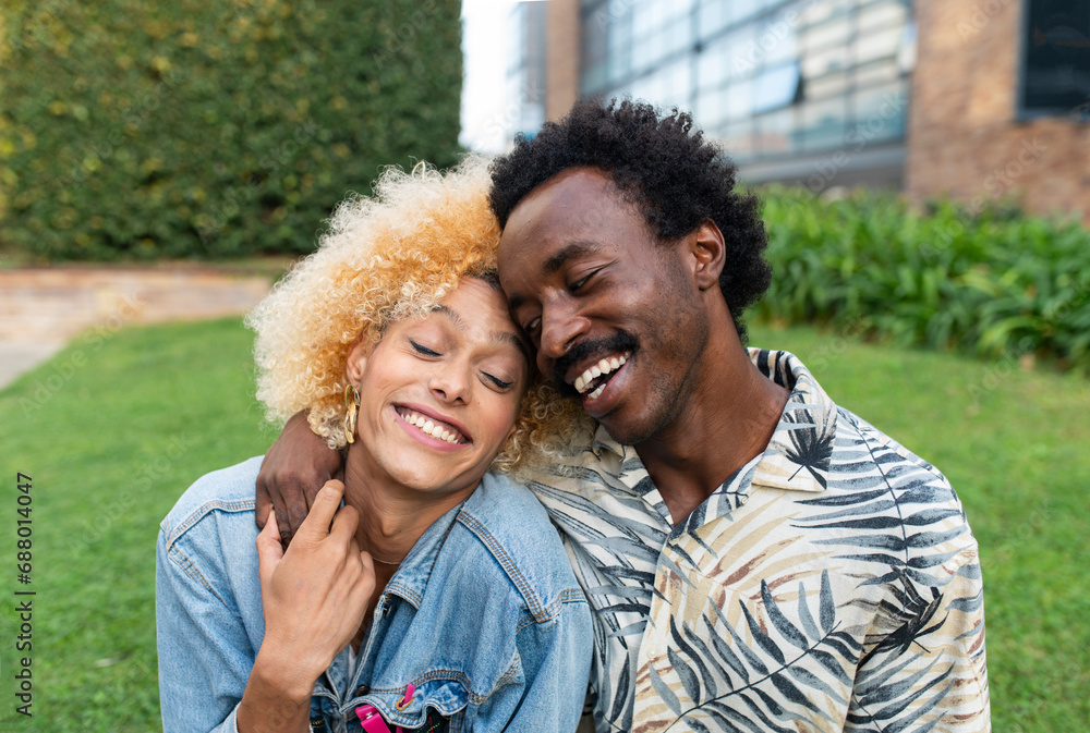 Smiling boyfriend embracing transgender woman at park Smiling boyfriend embracing transgender woman at park