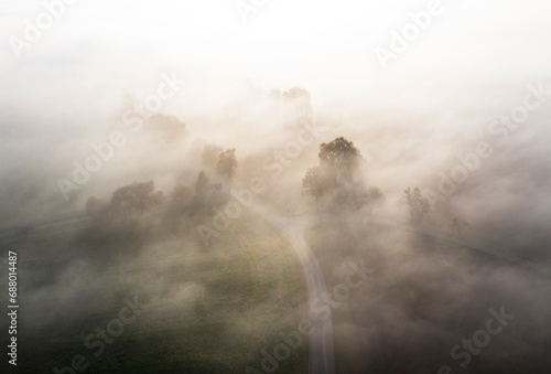 Austria, Upper Austria, Country road shrouded in thick morning fog photo