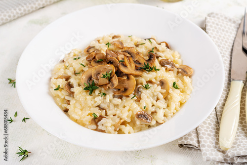 Dish with delicious risotto with mushrooms in plate. Rice porridge with fungus and tmyne. Hot dish, italian cuisine.