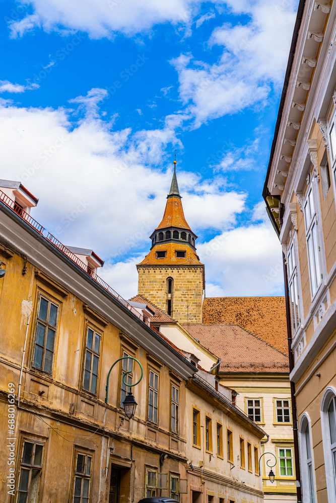 Fototapeta premium A Vibrant City Street with Majestic Buildings and an Enchanting Clock Tower. A street with buildings and a clock tower in the background