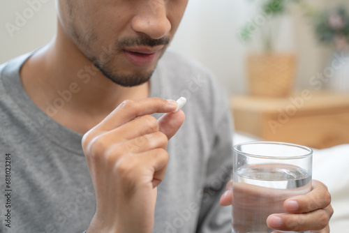 Fotografi Close-up a medicine tablet in young man hand taking painkiller