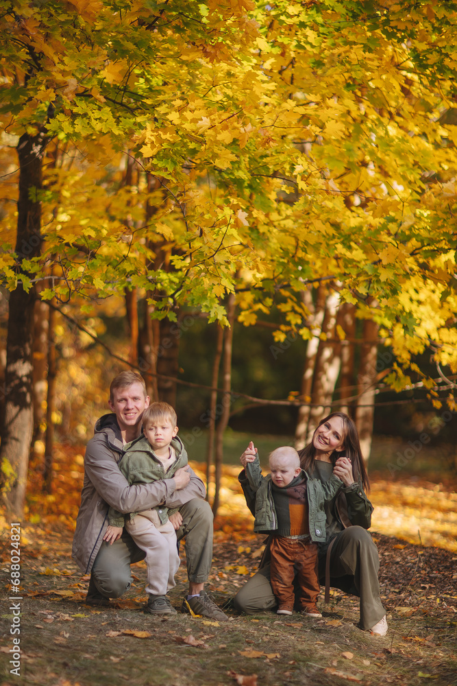 Smiling beautiful family of four walking in the park with a happy golden retriever and enjoying the beautiful autumn nature. Smiling beautiful family of four walking in the park with a happy golden retriever and enjoying the beautiful autumn nature.