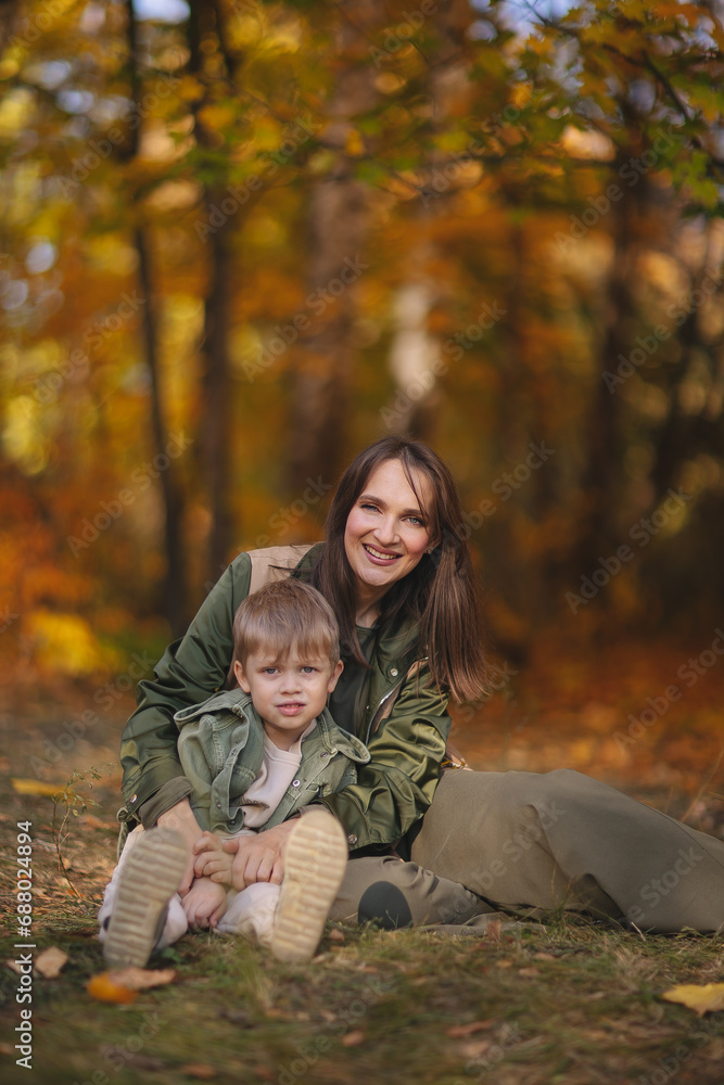 Mom and children walk in the park and enjoy the beautiful autumn nature. Happy family on an autumn walk. Natural Park. Family active holiday concept.