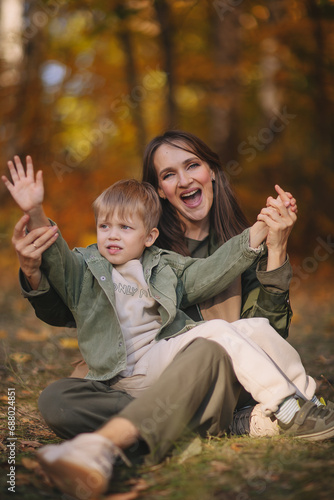 Mom and children walk in the park and enjoy the beautiful autumn nature. Happy family on an autumn walk. Natural Park. Family active holiday concept.