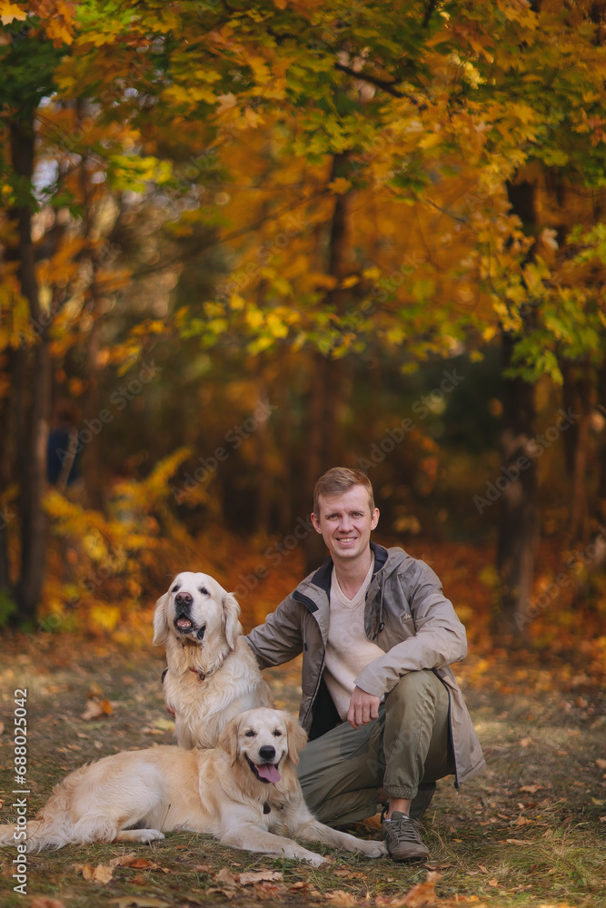 Smiling beautiful family of four walking in the park with a happy golden retriever and enjoying the beautiful autumn nature. Smiling beautiful family of four walking in the park with a happy golden retriever and enjoying the beautiful autumn nature.