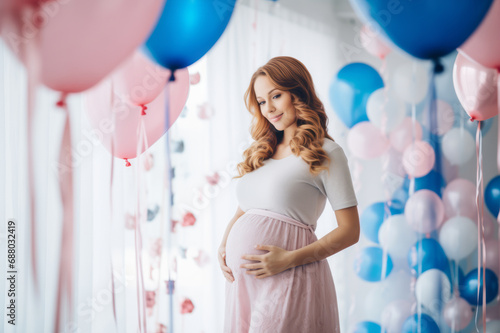 Beautiful young expecting mother surrounded by pink and blue balloons, confetti and streamers as a decorations at a gender reveal or a baby shower party.