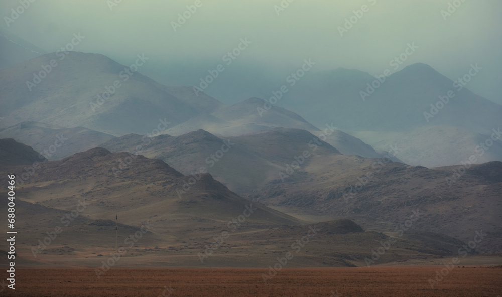 Steppe deserted mountains and hills in autumn foggy haze