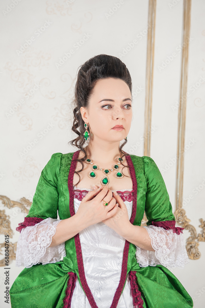 Young beautiful woman in rococo style medieval dress standing near wall Young beautiful woman in rococo style medieval dress standing near wall