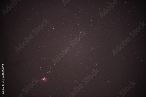 The constellation Orion and its belt in the dark night sky. Details of the Messier 42 Nebula.