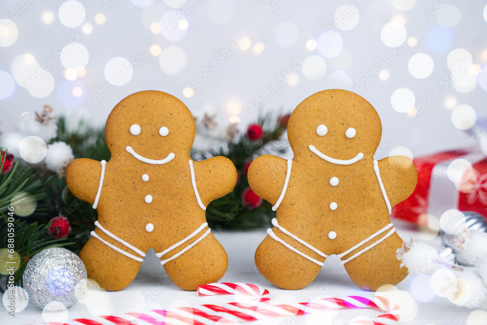 Obraz premium Gingerbread men and glass of milk on the Christmas table. Traditional Christmas treat for Santa. Close-up.