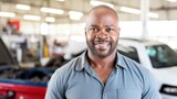 A cheerful adult man in automotive attire strikes a pose at the repair shop.