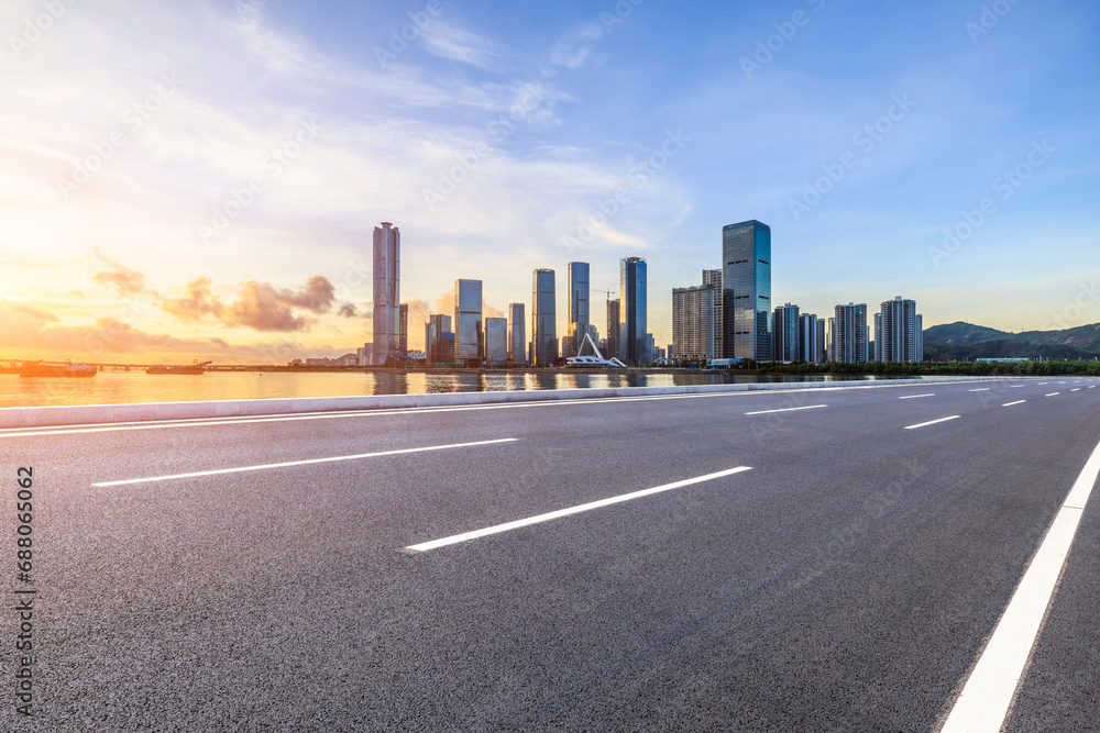 Asphalt highway road and city skyline with modern buildings at sunset in Zhuhai, Guangdong Province, China. Road and city skyline background.