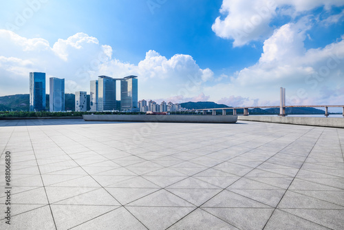 Empty square floor and modern city buildings under blue sky
