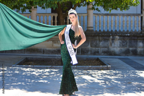 Bild auf Leinwand Pretty young woman winner of a beauty pageant dressed in a green sequined dress