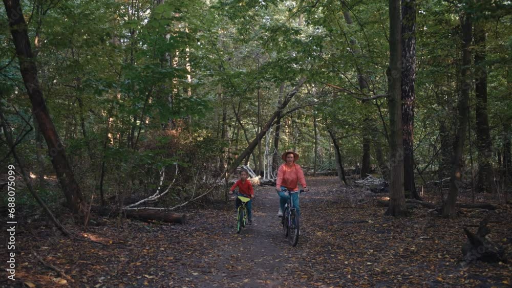 Mother and son are riding bicycles in the park. The family spends time together actively relaxing, enjoying and smiling while riding a bike. High quality 4k footage Mother and son are riding bicycles in the park. The family spends time together actively relaxing, enjoying and smiling while riding a bike. High quality 4k footage