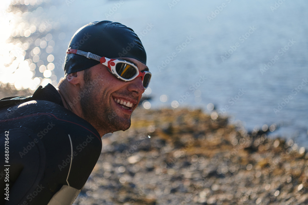 Authentic triathlon athlete getting ready for swimming training on lake Authentic triathlon athlete getting ready for swimming training on lake