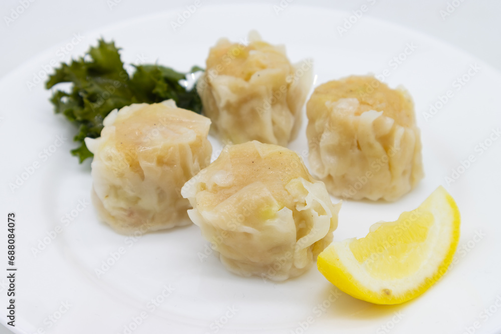 Japanese Ebi Shumai Shrimp Dumplings on a Plate with a Lemon Japanese Ebi Shumai Shrimp Dumplings on a Plate with a Lemon