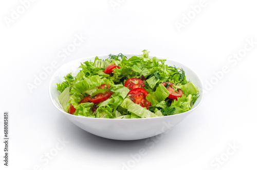 Front view of white bowl with vegetables isolated on white background. Green salad, dill, tomato.