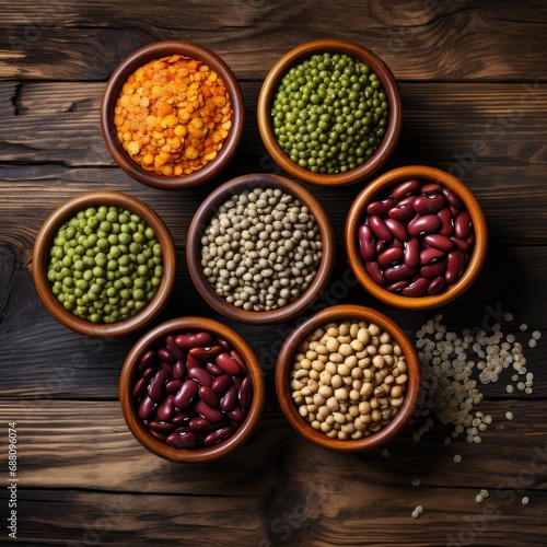 different varieties of beans and seeds in bowls on a wooden table