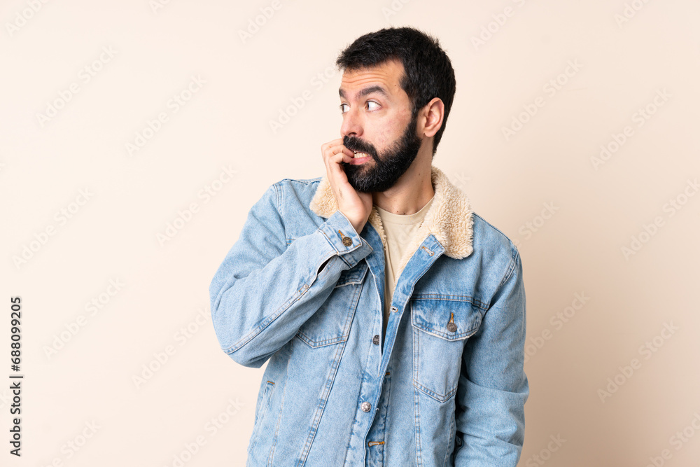 Caucasian man with beard over isolated background is a little bit nervous Caucasian man with beard over isolated background is a little bit nervous
