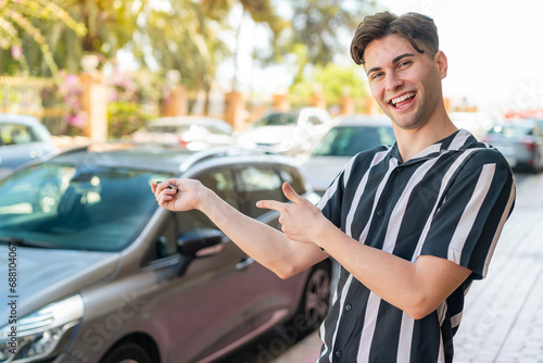 Young handsome man holding car keys with happy expression