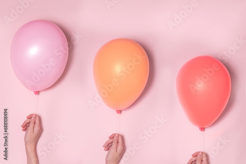 Pastel pink and colorfool balloons with females hands. Party concept. photo