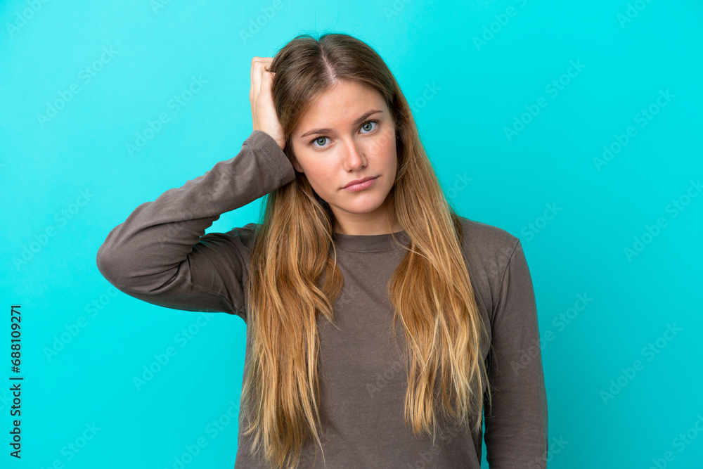 Young blonde woman isolated on blue background with an expression of frustration and not understanding Young blonde woman isolated on blue background with an expression of frustration and not understanding