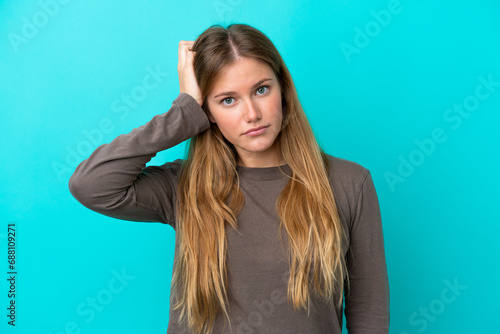 Young blonde woman isolated on blue background with an expression of frustration and not understanding