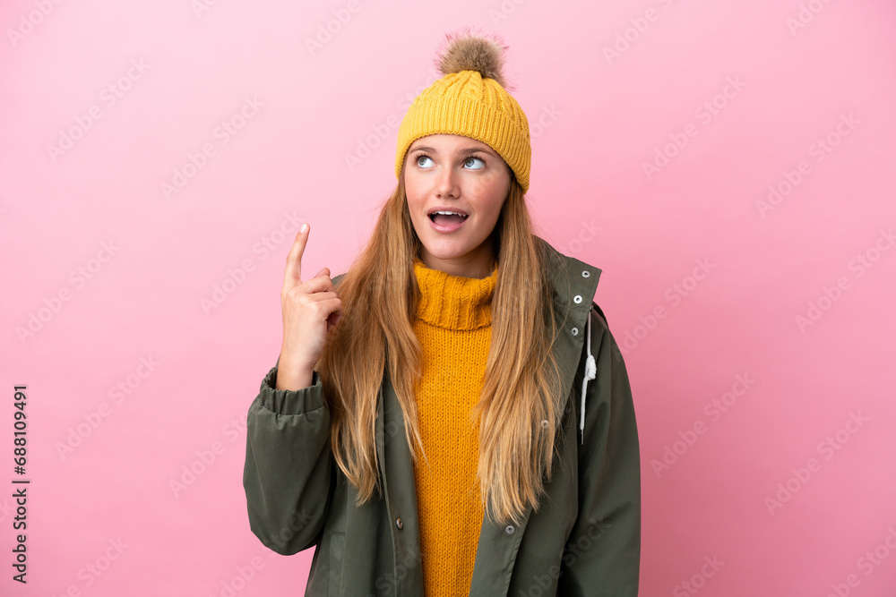 Young blonde woman wearing winter jacket isolated on pink background thinking an idea pointing the finger up Young blonde woman wearing winter jacket isolated on pink background thinking an idea pointing the finger up