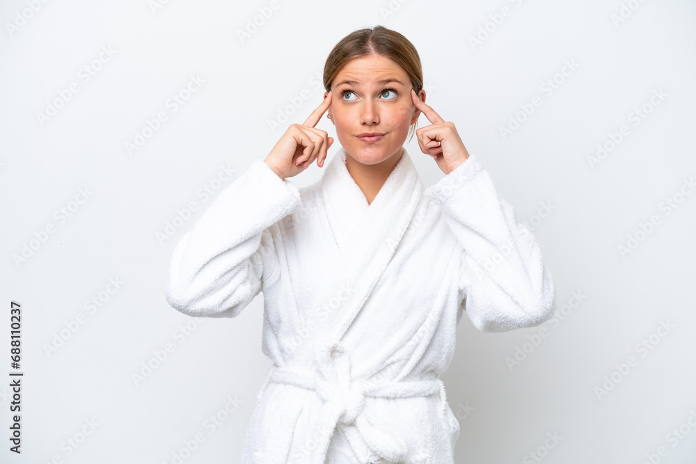 Young pretty blonde woman in bathrobe isolated on white background having doubts and thinking Young pretty blonde woman in bathrobe isolated on white background having doubts and thinking