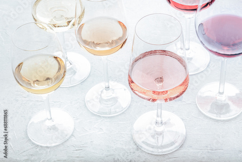 Wine glasses at a tasting. Rose, red, and white wine, drinks on a table at a winery, toned image. An assortment of wines of different colours and hues photo