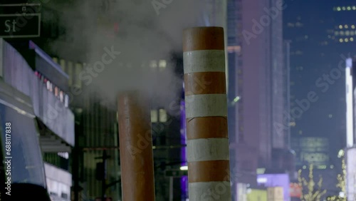 Steam chimneys on a New York City street at night