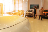 Blurred new car parked in modern showroom waiting for sales.