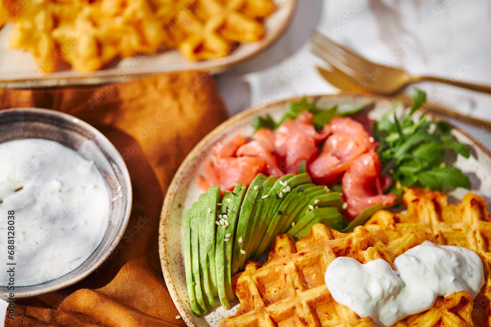 Hearty sweet potato or pumpkin waffles with avocado, salmon, arugula and sauce Hearty sweet potato or pumpkin waffles with avocado, salmon, arugula and sauce