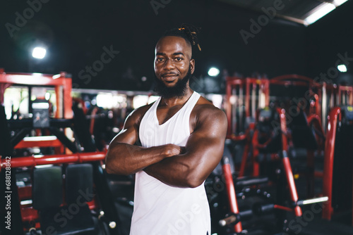 Cheerful black man with arms crossed standing in gym