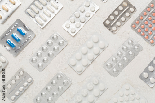 Pills in blister packaging on concrete background, top view