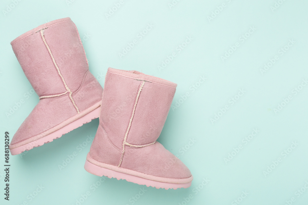 Beautiful childish ugg boots on color background,top view Beautiful childish ugg boots on color background,top view