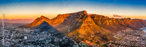 cape town aerial panorama from the table mountain at sunset  sun shining on the mountain range town in the dusk
